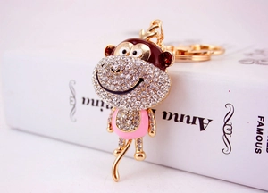 Detailed macro shot of a crystal-studded monkey keychain with colorful enamel accents