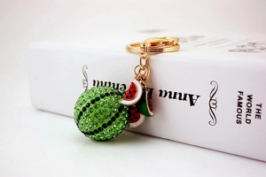 Detailed view of sparkling rhinestone watermelon keychain with gold metal ring and enamel charms