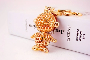 Detail of golden zodiac monkey keychain with heart patterns, crown, and rhinestones