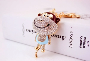 Detailed view of monkey keychain with sparkling rhinestones and blue enamel on metal base