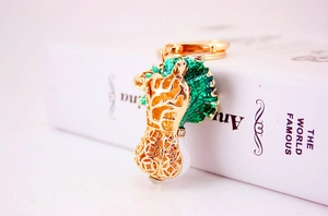Macro shot of cabbage keychain with green enamel leaves and golden hollow coin pattern