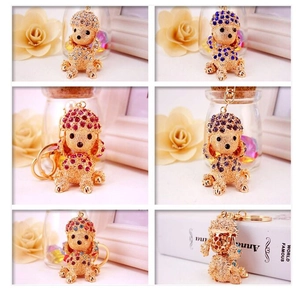 Detailed macro view of multicolored crystal-studded poodle keychains with gold-tone hardware