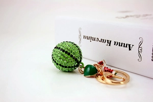 Detail of sparkling rhinestone watermelon keychain with gold chain on a book