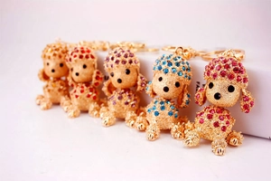 Detail of five puppy keychains with colorful rhinestones on golden alloy metal rings