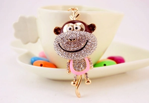 Close-up of golden alloy monkey keychain with sparkling rhinestones and brown enamel finish