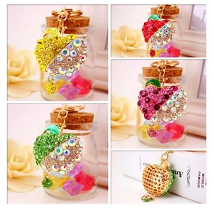 Detailed views of apple rhinestone keychains in vibrant colors with gold metal backing