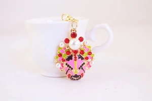 Detail of Chinese Beijing Opera mask keychain with pink enamel and white pearls