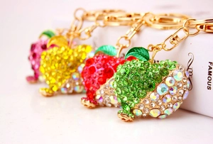 Detailed close-up of colorful rhinestone apple keychains in pink, yellow, red and green