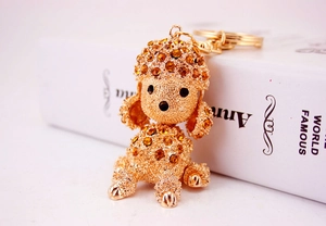 Macro shot of gold-plated poodle keychain encrusted with glowing amber crystals