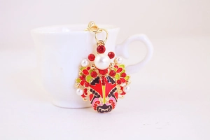 Detail of Peking Opera face keychain with enamel craft, red rhinestones and pearls