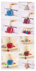 Detailed view of apple-shaped keychains with colorful rhinestones on a gold ring
