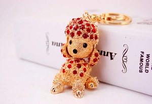 Macro shot of gold alloy poodle keychain with vibrant red rhinestones on book