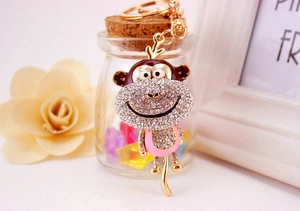 Detailed view of monkey keychain featuring pink enamel, white rhinestones and gold alloy