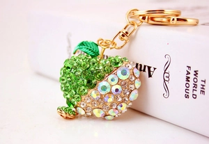 Close-up of green apple keychain with sparkling rhinestones and golden lobster clasp