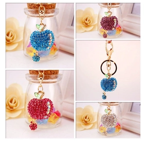 Detailed view of rhinestone apple keychains in blue, red, purple, and silver colors