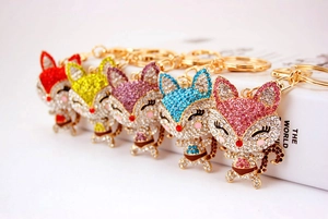Detail of colorful rhinestone cartoon fox keychains with glittering crystals and gold rings