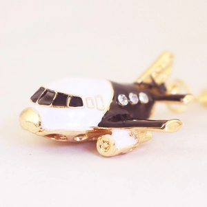 Porte-clés avion doré créatif avec émail noir et blanc et strass étincelants
