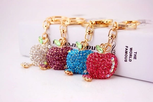 Detail of four colorful crystal apple keychains with gold-tone alloy base and lobster clasp