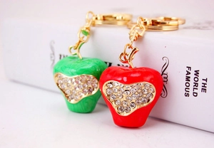 Detailed macro view of creative apple-shaped keychains with sparkling heart-shaped rhinestones