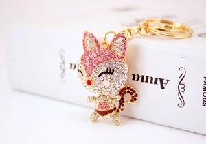 Detail of a cute cartoon fox keychain with sparkling pink rhinestones and gold clasp