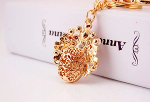 Detailed close-up of golden hollowed-out filigree metal pendant with crown design
