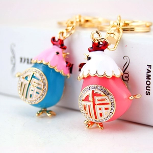Portachiavi gallina in smalto con carattere Fu dorato e cristalli in blu e rosa confetto