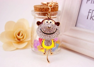 Close-up of golden alloy monkey keychain with sparkling white and brown rhinestones