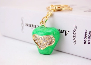 Detail of green marble apple keychain with a sparkling rhinestone heart and gold chain
