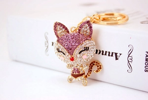 Close-up of cute cartoon fox keychain with sparkling rhinestones and gold-tone metal plating