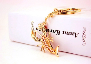 Détail d'un porte-clés homard doré créatif avec des strass blancs étincelants et finition polie