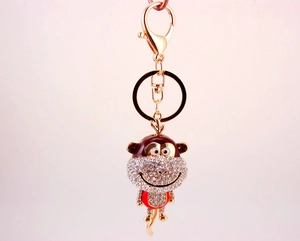 Macro view of rhinestone-encrusted monkey keychain with golden finish and lobster clasp