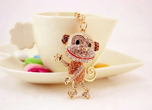 Detail of creative monkey keychain with rhinestones hanging on a ceramic cup