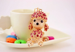 Close-up of golden poodle keychain with rose red rhinestones in warm lifestyle setting