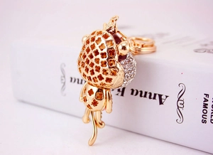 Detailed macro of golden monkey keychain with sparkling rhinestones and clover patterns