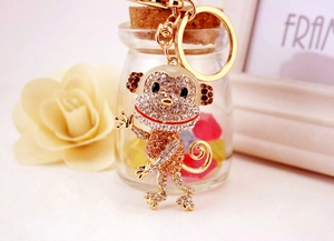 Close-up of golden monkey keychain with white and champagne sparkling rhinestones