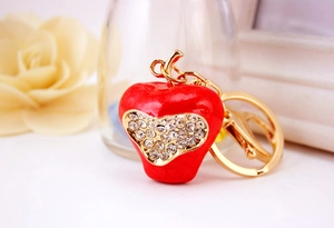 Detail of red apple keychain with sparkling heart rhinestone and gold plated clasp