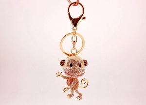 Detailed macro view of a gold monkey keychain with sparkling crystal rhinestones and lobster clasp