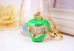 Close-up of green apple keychain with sparkling heart rhinestones and golden hardware