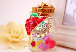 Close-up of apple keychain with red and iridescent rhinestones and gold chain