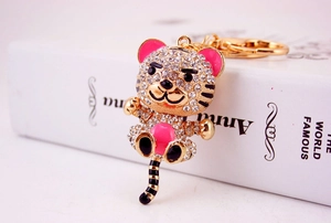 Detailed view of a gold-plated tiger keychain featuring sparkling rhinestones and pink enamel