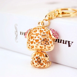 Cute golden alloy dog keychain with heart cutouts and pink rhinestones on ears