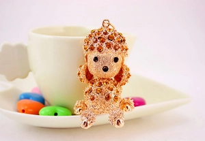 Sparkling rhinestone dog keychain next to a white coffee cup and colorful heart decor