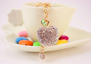 Close-up of sparkling crystal-studded apple keychain with gold-plated lobster clasp detail