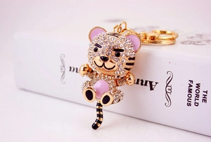 Macro shot of sparkling rhinestone tiger keychain with elegant gold-plated metal and pink enamel