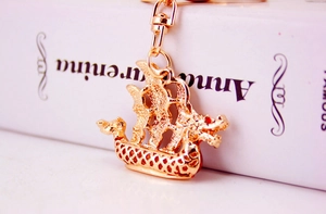 Dettaglio ravvicinato di un portachiavi a forma di barca a drago cinese in metallo dorato