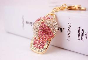 Detailed macro view of pink rhinestone baseball cap keychain with gold lobster clasp
