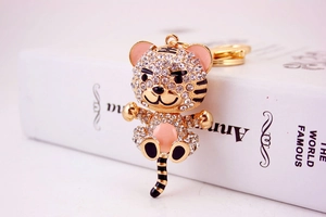 Detailed macro view of gold-plated cartoon tiger keychain with white rhinestones