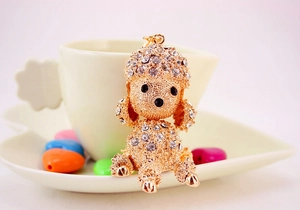 Detailed close-up of a gold poodle keychain with sparkling white rhinestones in macro view