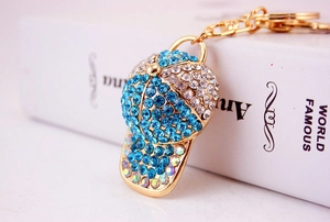 Macro shot of creative baseball cap keychain with blue rhinestones and gold plating