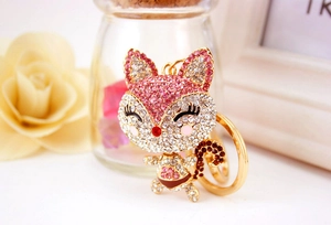 Detailed close-up of a golden fox keychain with sparkling pink and clear crystals
